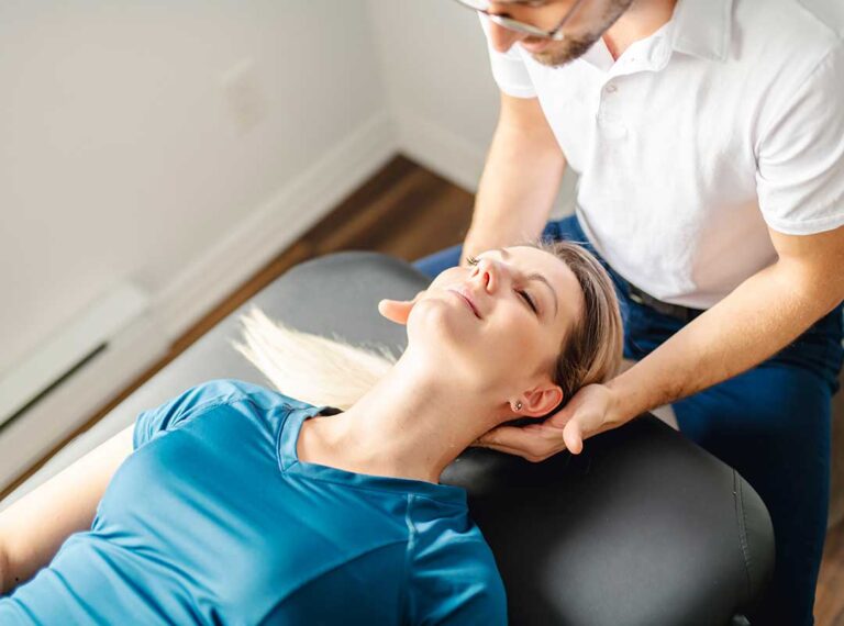 A chiropractor discussing spine health with a patient in a bright community wellness office.